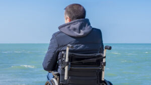 man on wheelchair on beach