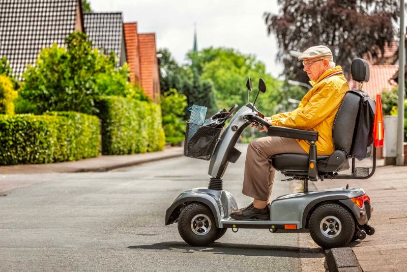 Man on mobility scooter crossing a road