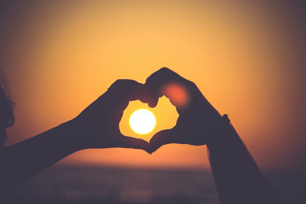 Love heart hands over a sunset