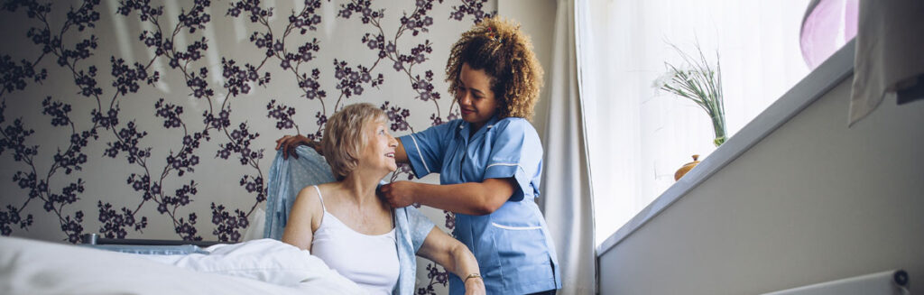 Carer helping someone get dressed