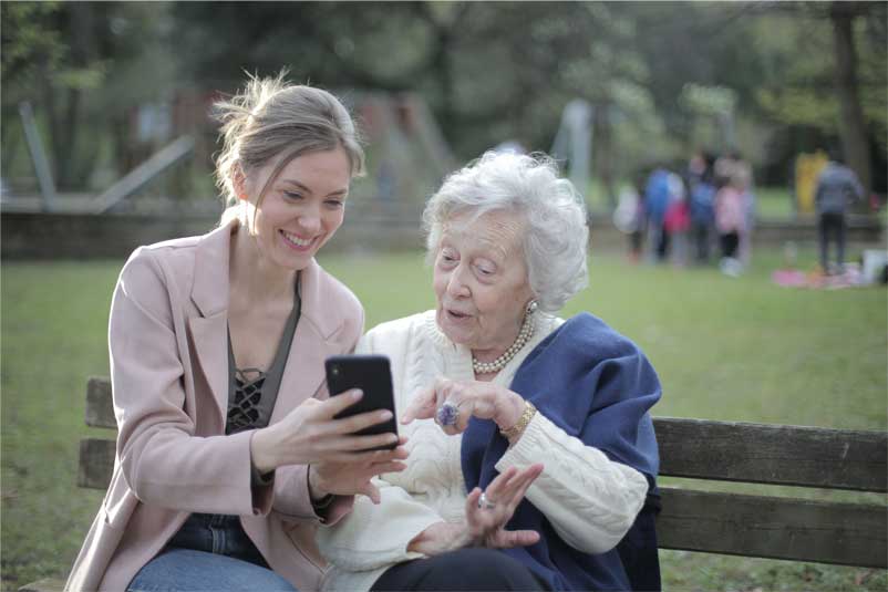 A lady and an elderly lady looking at a mobile phone