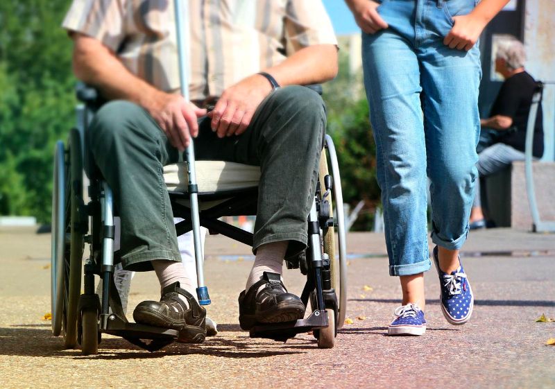 Wheelchair user and person walking next to them